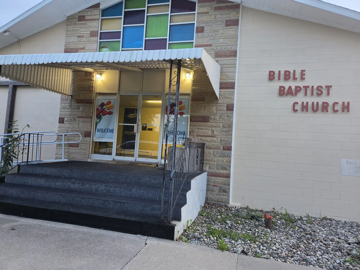 Main entrance of Bible Baptist Church with stained-glass windows and a wheelchair-accessible ramp